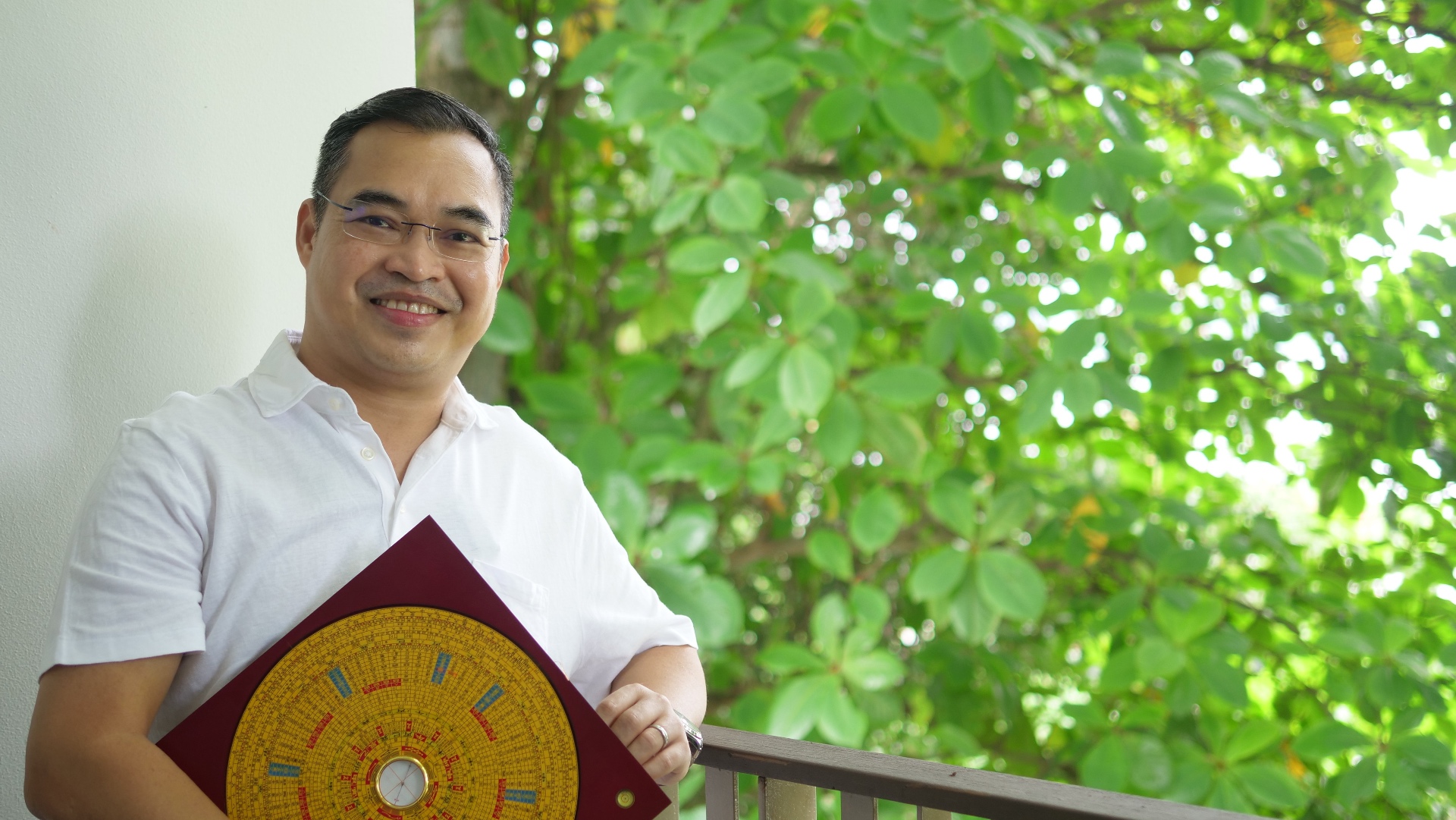 Thanapark holding a Feng Shui luopan compass